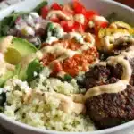 Overhead view of a protein-rich burger bowls filled with beef, vegetables, and sauce