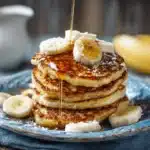 Stack of cottage cheese banana pancakes with banana and yogurt topping