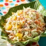 Hawaiian Pineapple Coleslaw 9 Bowl of Hawaiian pineapple coleslaw with colorful vegetables and pineapple chunks.