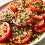 Marinated Tomatoes 12 Fresh marinated tomatoes in a bowl, seasoned with herbs and spices.