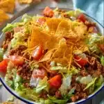Simple Doritos Taco Salad 8 A vibrant bowl of simple Doritos taco salad topped with fresh ingredients and crunchy Doritos.